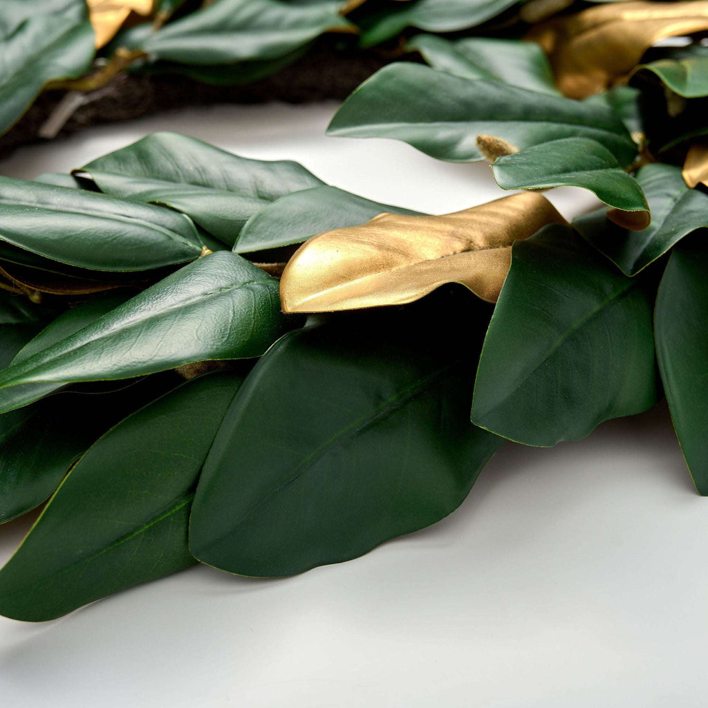 Decorative wreath with green leaves and gold accents on a white background