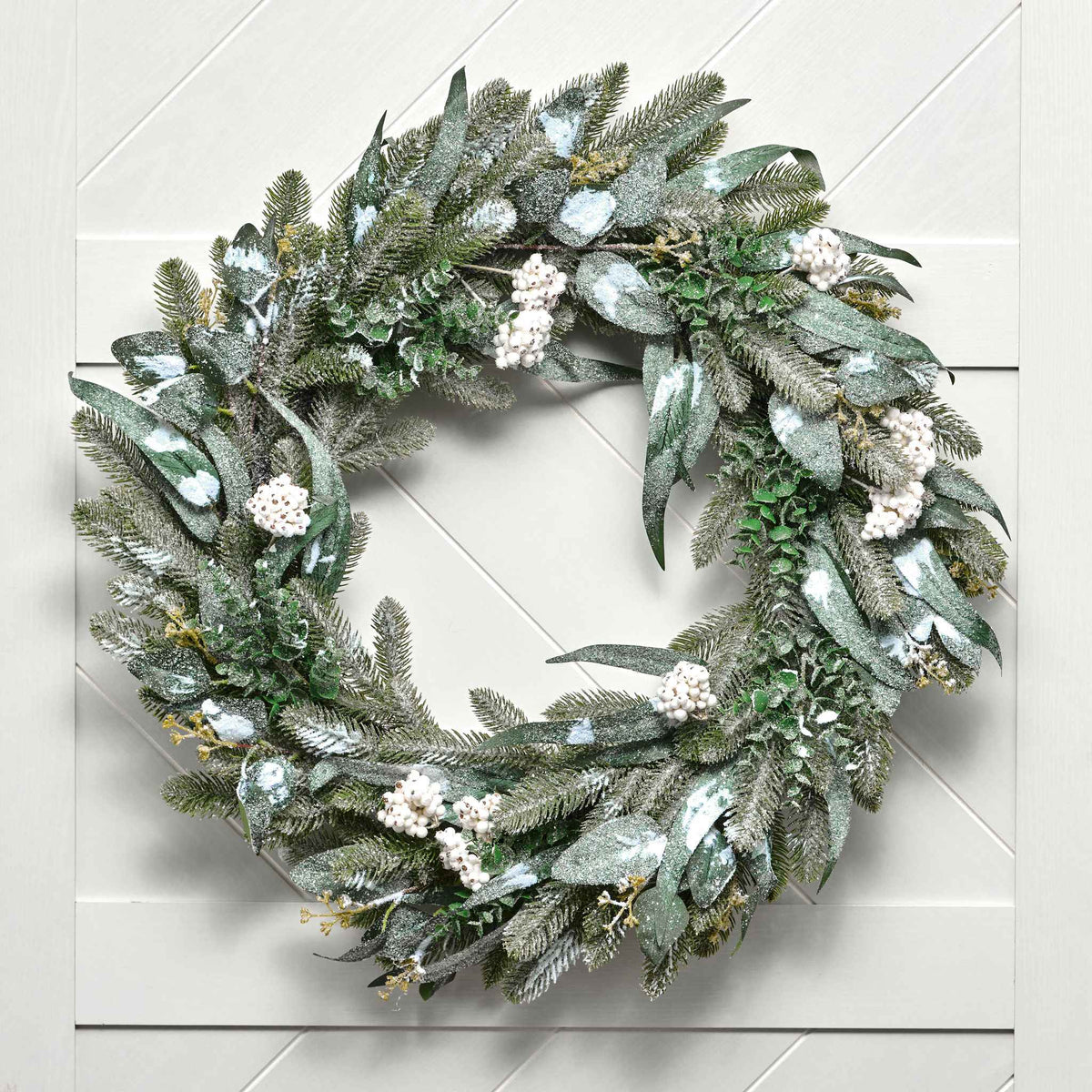 Green wreath with white flowers on a light gray background