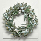 Green wreath with white flowers on a light gray background
