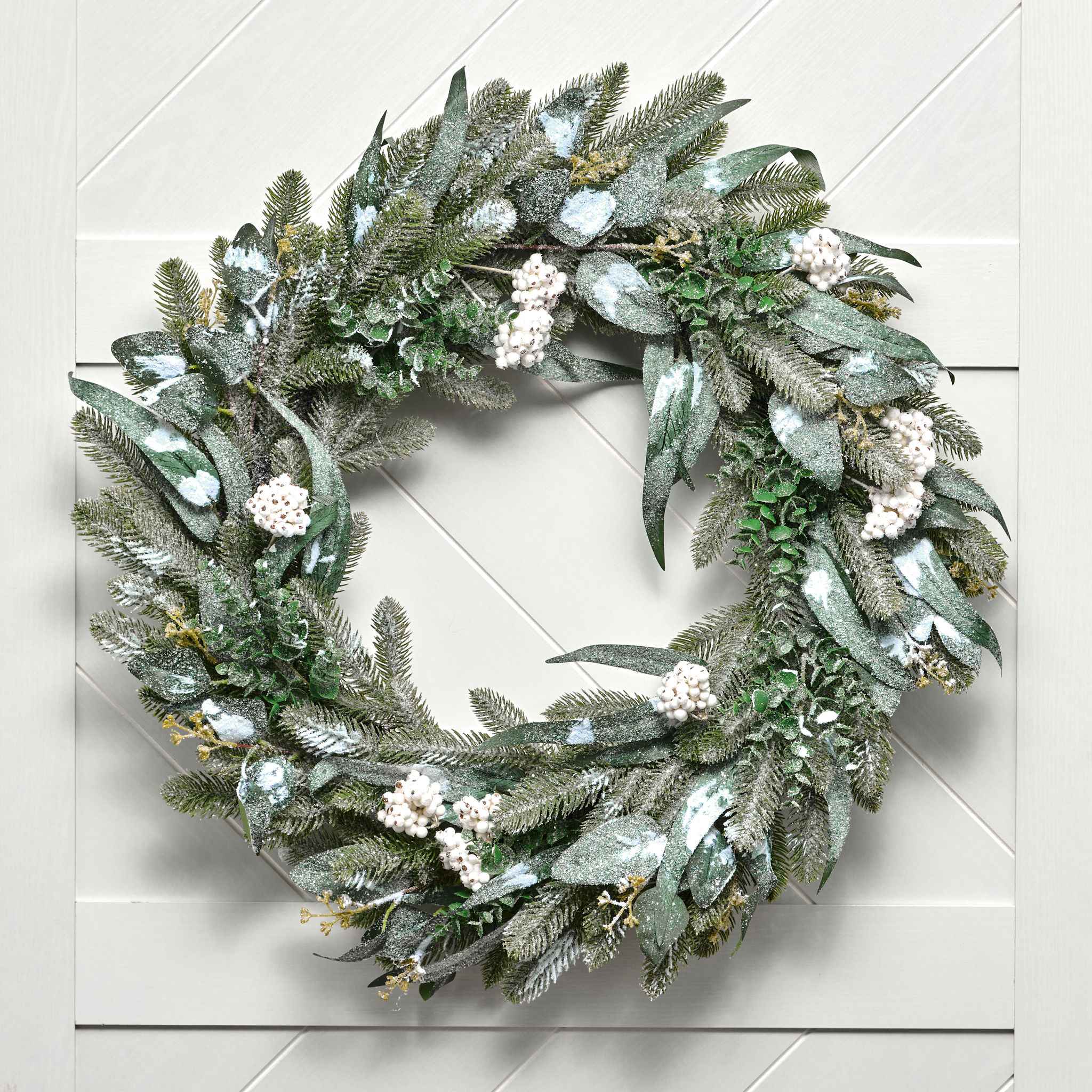 Green wreath with white flowers on a light gray background